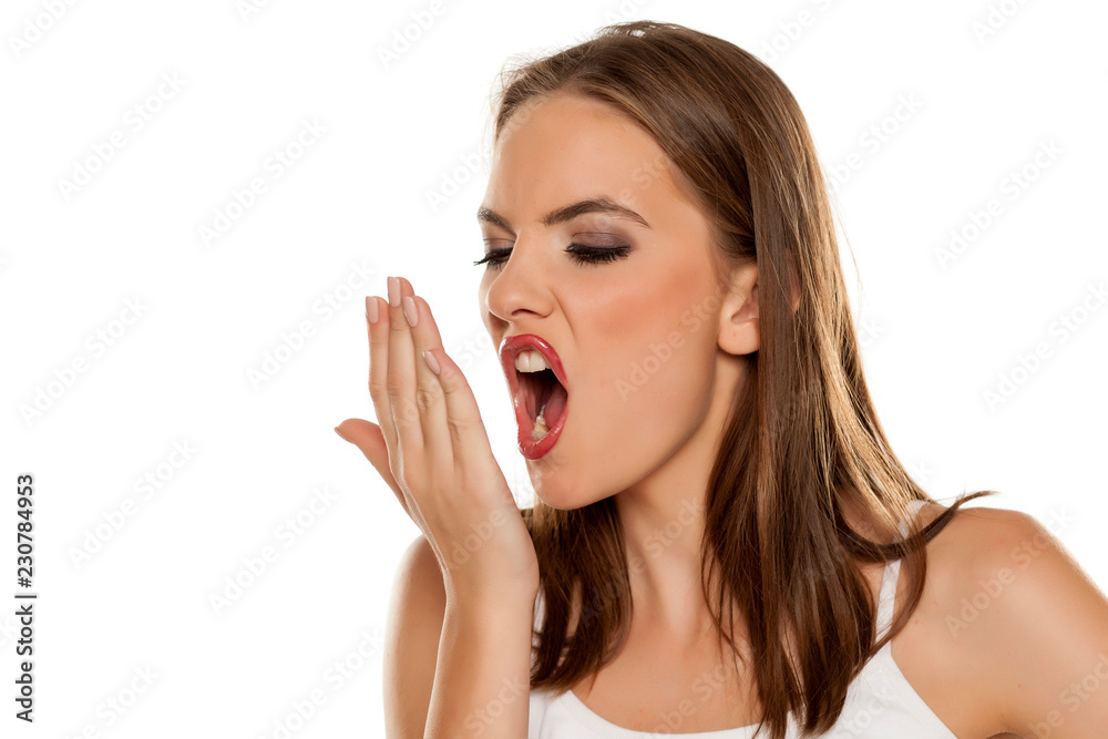 Beautiful girl checking her breath on white background Beautiful girl checking her breath on white background