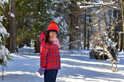 Girl in a red hat for a walk in the woods on a snowy winter day.  © Лариса Левина