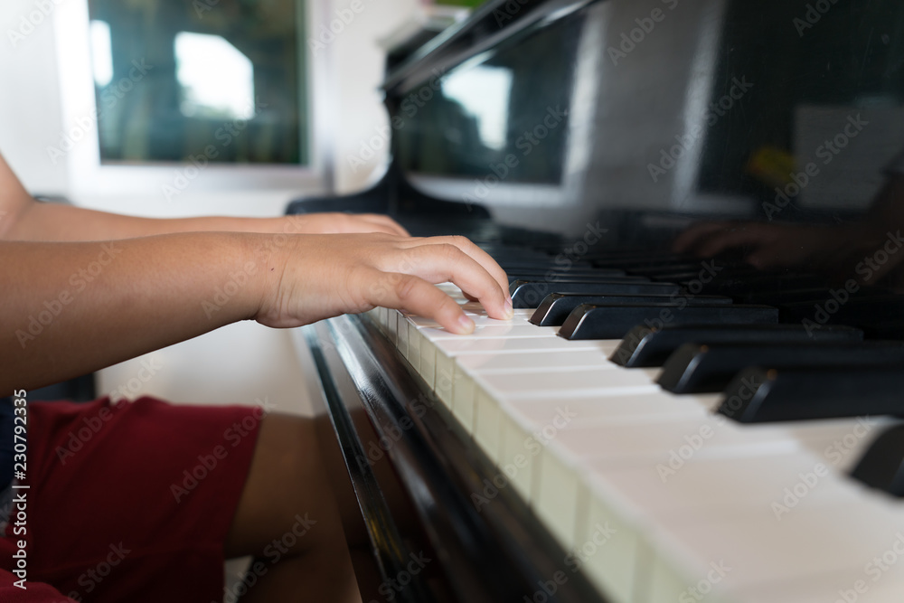 Hand of asian kid playing piano in the room Stock Photo | Adobe Stock
