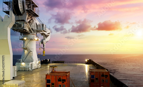 Amazing Sunset view from a modern offshore ship with a large crane on deck photo