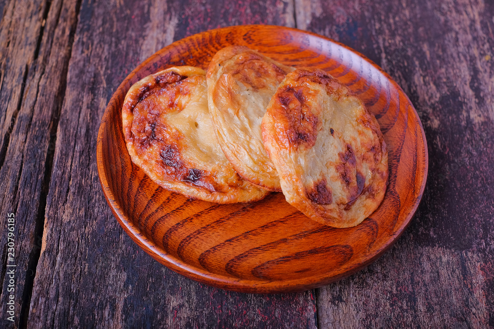 Akok Kedut on wooden plate over the wooden table. Akok Kedut is a traditional dish in Malaysia especially East Coast.