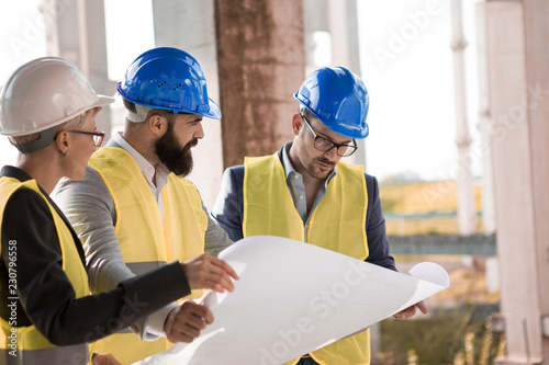 The investor is very curious looking at new solutions on blueprints from the young architect hipster. 