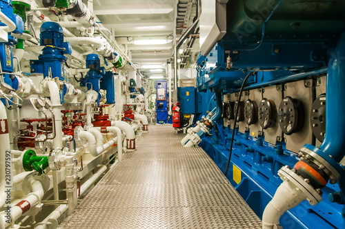 Equipment, cables, pipes and valves in engine room of a ship power plant