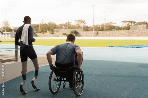 Two disabled athletes walking together in stadium