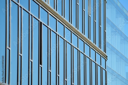 Modern office building facade abstract fragment, shiny windows in steel structure