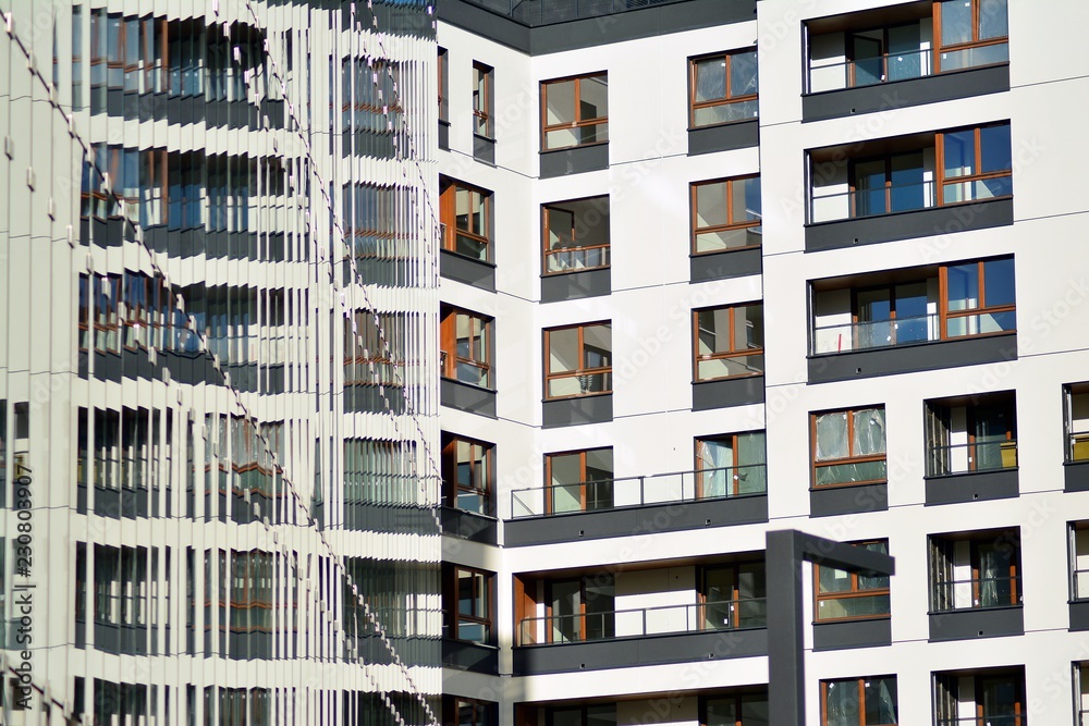 Modern apartment buildings on a sunny day with a blue sky. Facade of a modern apartment building Modern apartment buildings on a sunny day with a blue sky. Facade of a modern apartment building