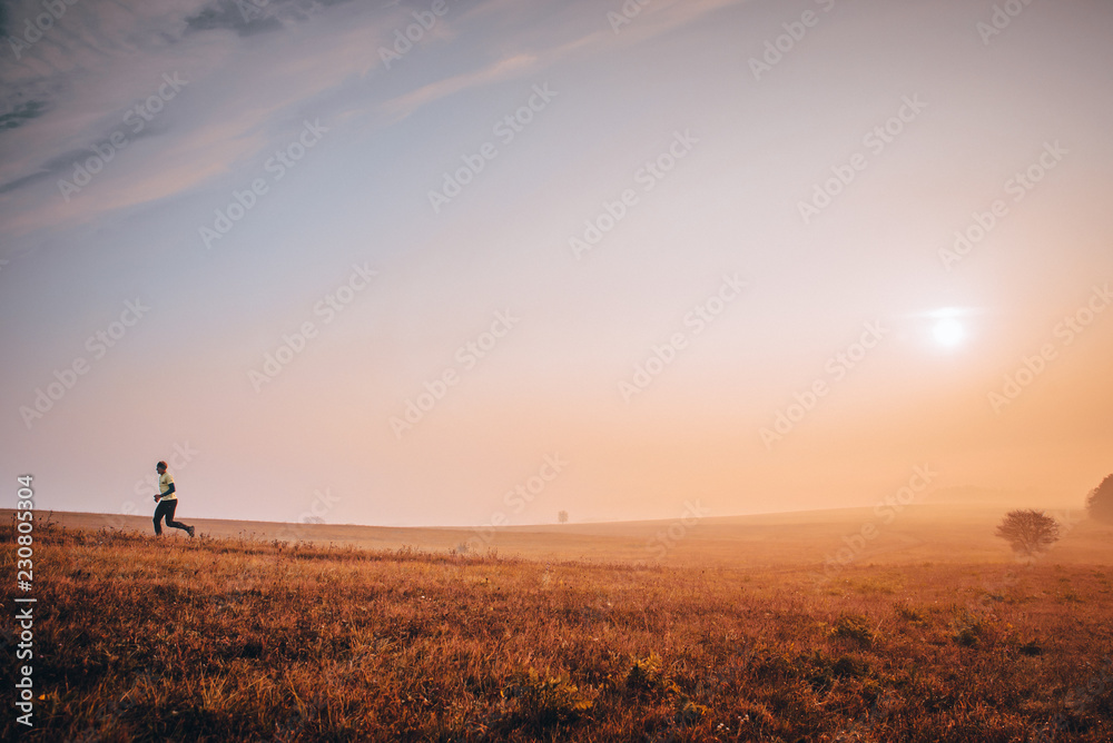 Man running in autumn nature. Morning exercise sport photo