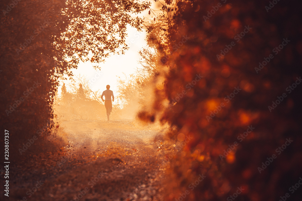 Man running in orange autumn misty nature
