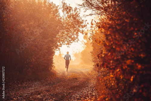 Man train in autumn nature. Running sport photo.