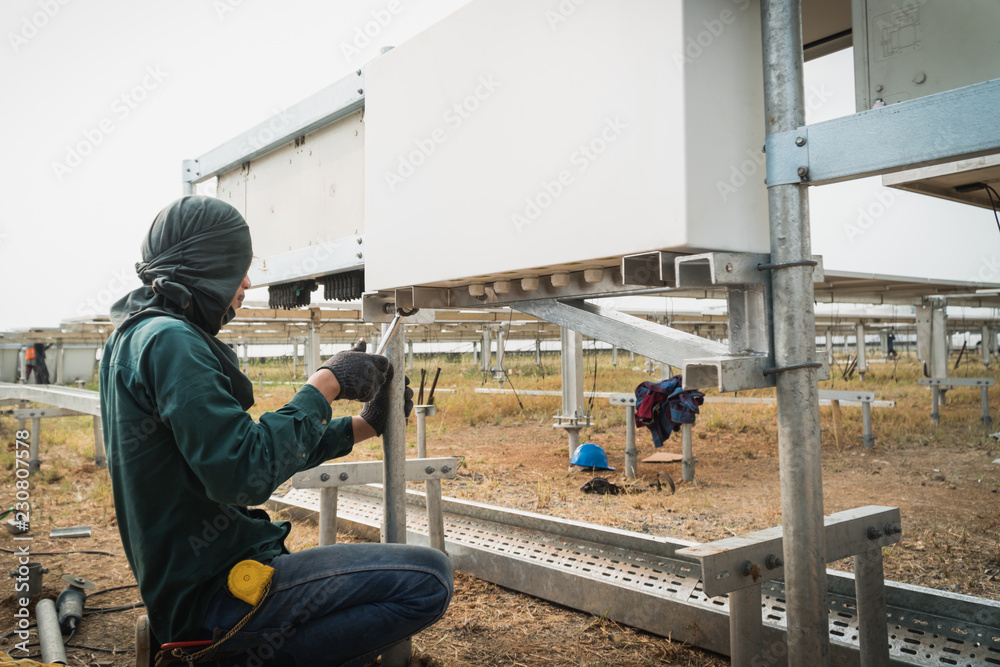 engineer and electrician installing solar power plant; scope of work at solar power plant tracking to sun engineer and electrician installing solar power plant; scope of work at solar power plant tracking to sun