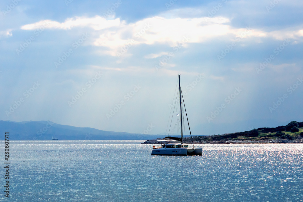Sailing boat on the sea at sunset. Summer evening on an island in Greece.