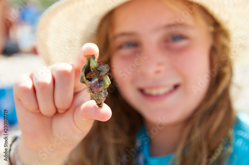 Blonk kid girl holding hermit crab photo