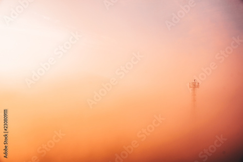 Man at the top of tower in colorful morning mist