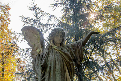 Old historical gravestone of sad woman or type of angel on a cemetery. Concept of sadness and religious peacefulness