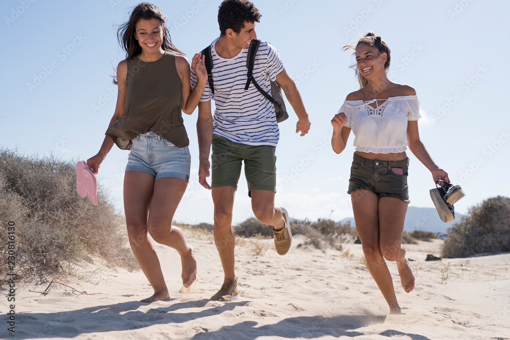 Friends having fun, running barefoot on the beach Friends having fun, running barefoot on the beach