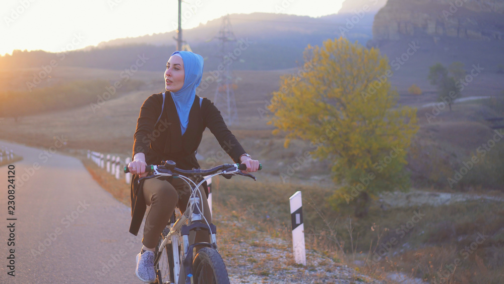 Portrait Of A Muslim Woman In Hijab Riding A Bike On The Way Stock 