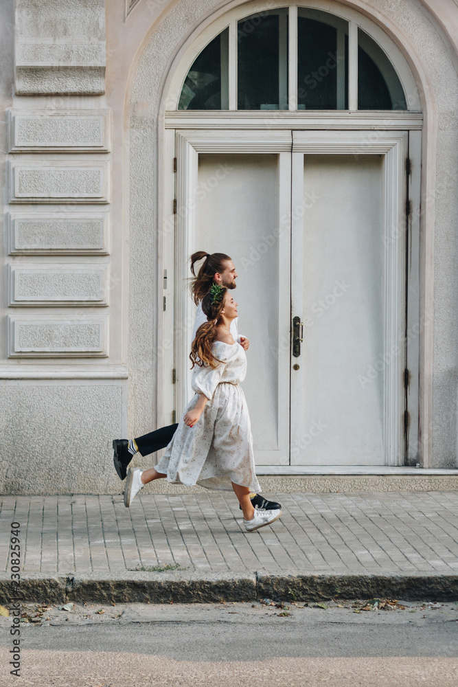 Beautiful couple running in front of building Beautiful couple running in front of building