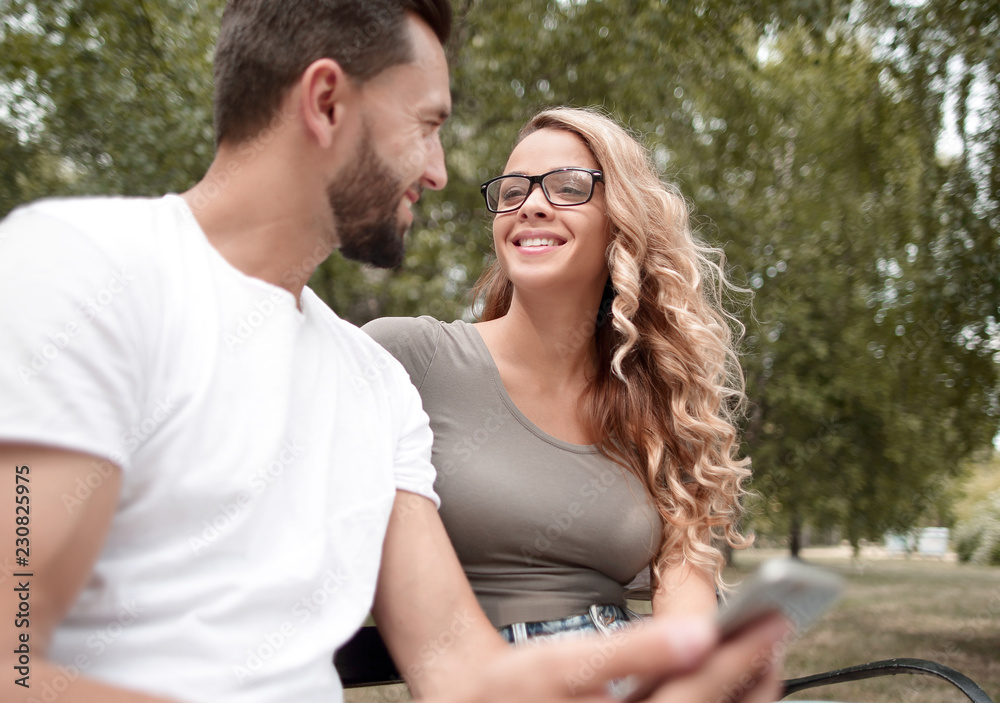 young couple sitting on a bench in a city Park. young couple sitting on a bench in a city Park.