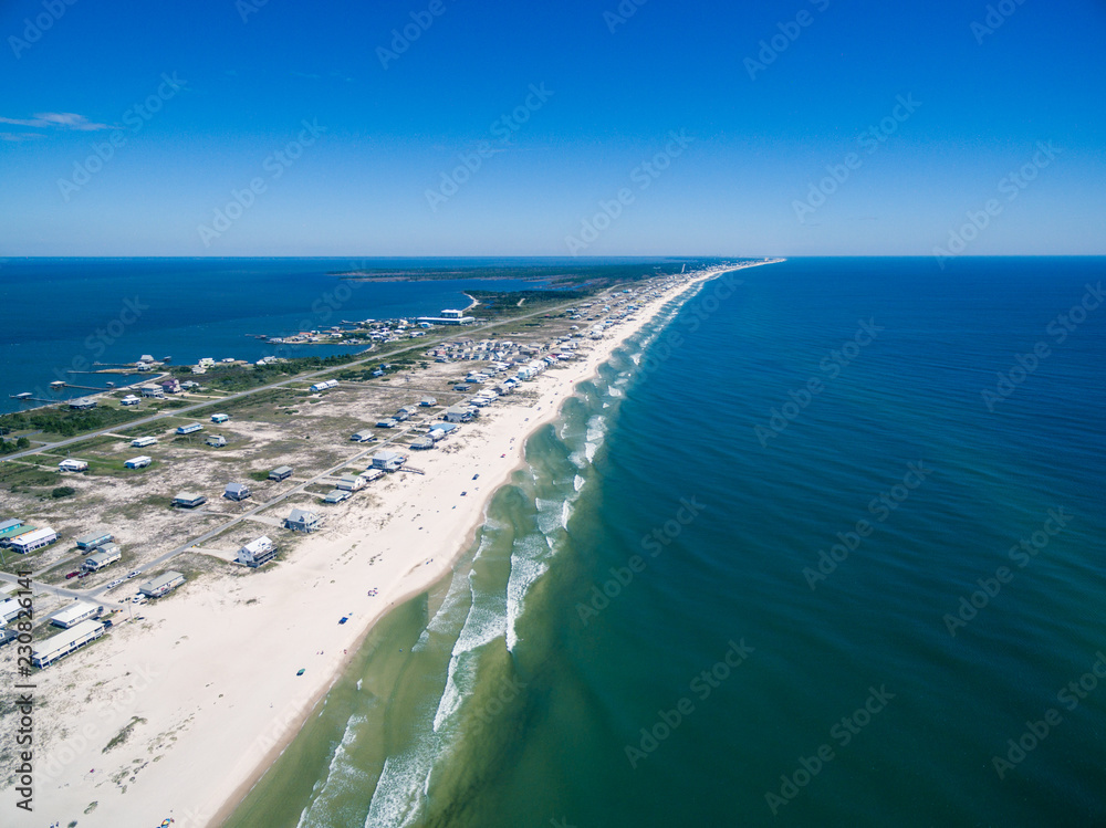 Drone/Aerial ocean photograph of the Gulf Shores/Fort Morgan peninsula. The warm Gulf of Mexico washes onto this pristine white sand beach. Alabama, USA