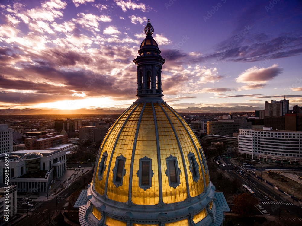 Aerial/Drone photograph of a sunset over the Colorado state capital building.  Capital city of Denver.  The Rocky Mountains can be seen on the horizon - obrazy, fototapety, plakaty 