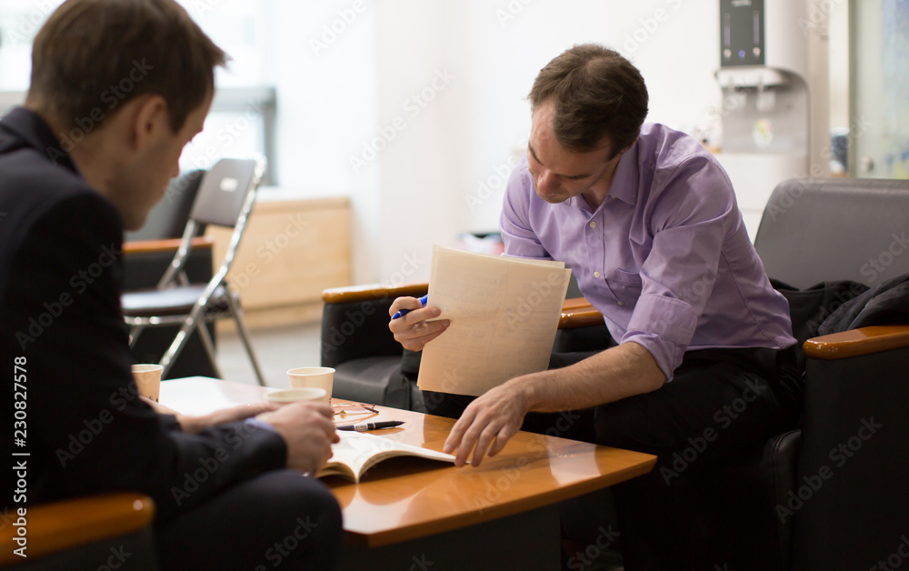 Business Meeting with People Reviewing Business Plans. Job Interview by Hiring Manager. Expert Businessmen. Career Legal Advisor is Reading and Presenting Documents to Client or Employee. Business Meeting with People Reviewing Business Plans. Job Interview by Hiring Manager. Expert Businessmen. Career Legal Advisor is Reading and Presenting Documents to Client or Employee.