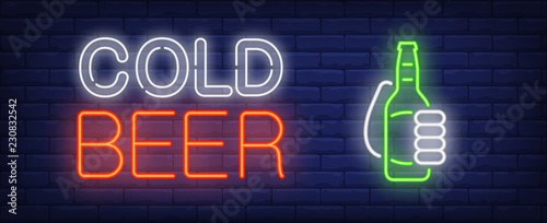 Cold beer neon sign. Glowing neon inscription with beer bottle in hand on dark blue brick background. Can be used for shops, night advertisements, bars, street signs