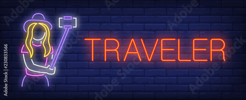 Traveler neon sign. Glowing inscription with girl silhouette in hat with smartphone and selfie stick. Can be used for web-sites, advertisement, travel magazines, travel agencies