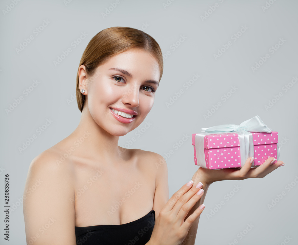 Happy woman holding gift and smiling Happy woman holding gift and smiling