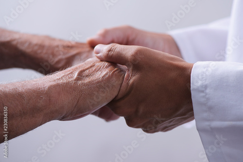 man holding the hands of a senior man photo