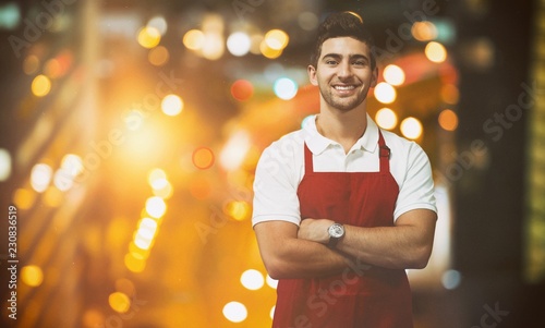 Composite image of portrait of confident male owner with arms photo