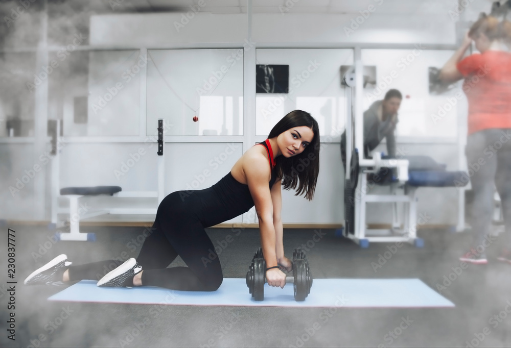 Fototapeta premium Beautiful girl in the gym, sportswear, athletic build.