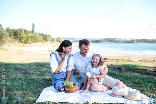 Happy family on picnic near the lake.