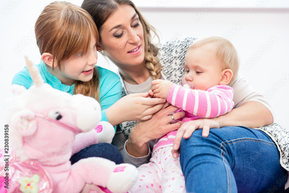 Smiling mother sitting with her children at home Smiling mother sitting with her children at home