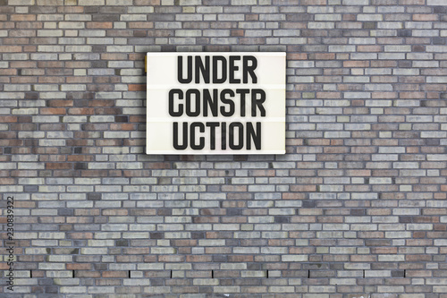 Under Construction in light box on brick wall