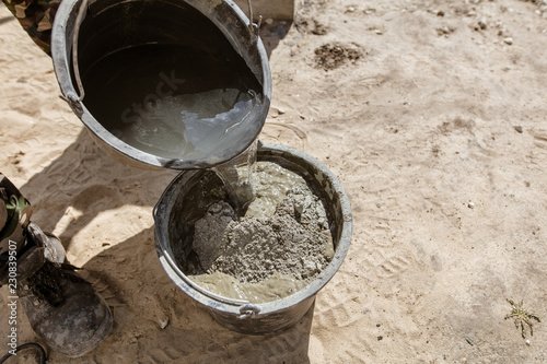 Mixing of concrete in a bucket at a construction site