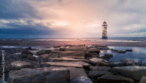 Point Of Ayr Lighthouse Talacre Beach rocks in forground.