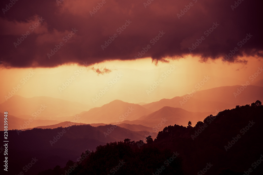 Overlapping mountains with cloudy and rain