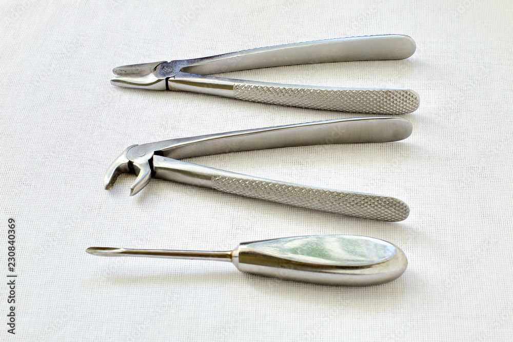 Retro. Black and white photography. Metal dental instruments for removing teeth on sterile white gauze background Retro. Black and white photography. Metal dental instruments for removing teeth on sterile white gauze background