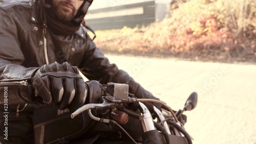 Person in leather gloves on motorbike start handle ready to go