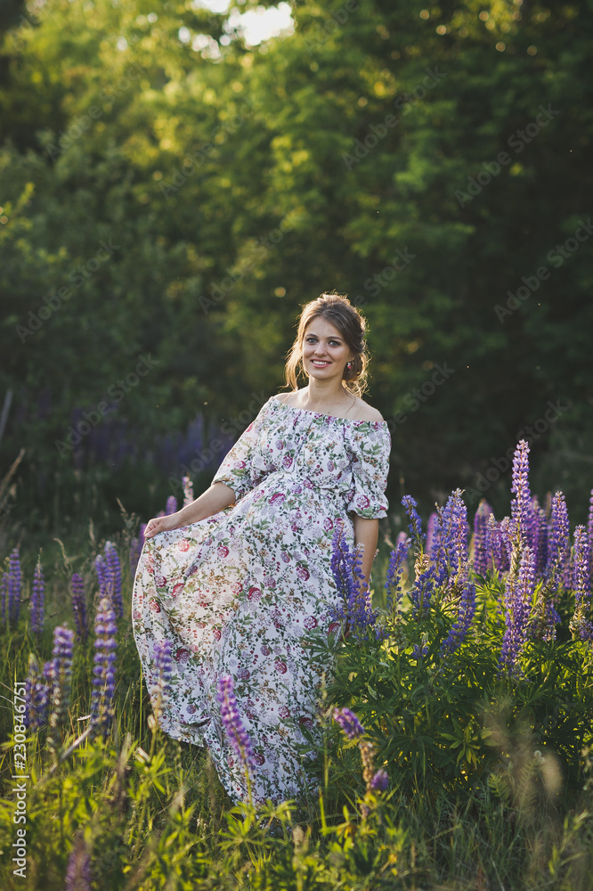 A pregnant girl walks through the blooming lupine field 1682. A pregnant girl walks through the blooming lupine field 1682.