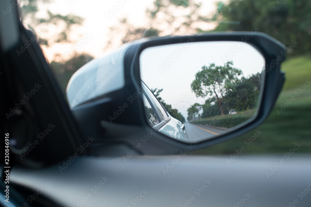 Side rear-view mirror on a new modern white car.