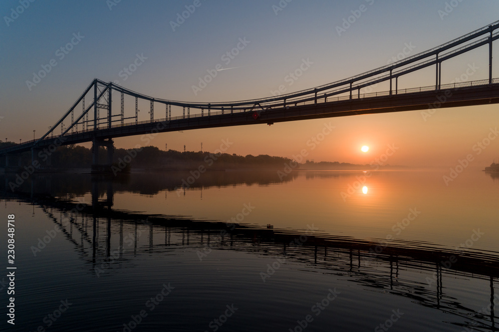 Sunrise aerial view of pedestrian Park bridge and Dnipro river in Kyiv, Ukraine