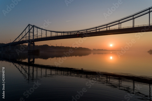 Sunrise aerial view of pedestrian Park bridge and Dnipro river in Kyiv, Ukraine