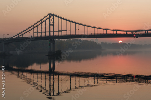 Sunrise view of pedestrian Park bridge and Dnipro river in Kyiv, Ukraine