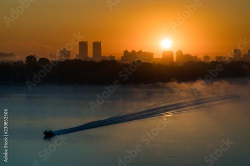 Boat sailing Dneper river before sunrise early in the morning in Kyiv, Ukraine. photo