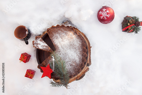 Banana cake bread traditional pie on snow surfase for Christmas dessert table. Christmas New Year decorations. photo