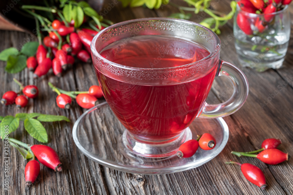 A cup of rose hip tea with fresh rose hips A cup of rose hip tea with fresh rose hips