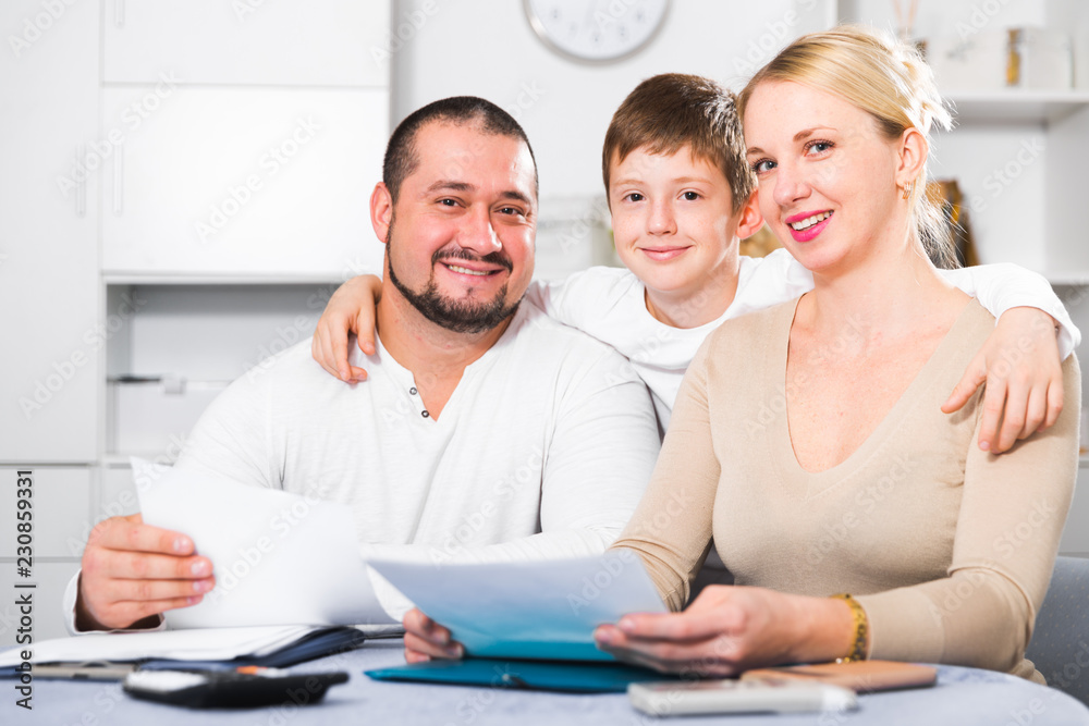 Fototapeta premium Happy parents with son looking at documents