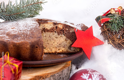 Banana cake bread traditional pie on snow surfase for Christmas dessert table. Christmas New Year decorations. photo