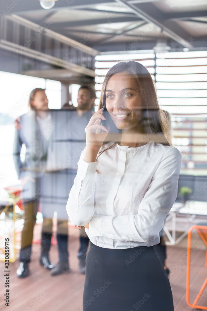 Beautiful businesswoman using a cell phone in her office Beautiful businesswoman using a cell phone in her office
